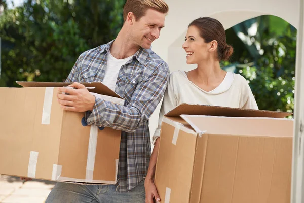 A mudar-se para a nossa nova casa. Tiro de um jovem casal carregando caixas em uma nova casa juntos. — Fotografia de Stock