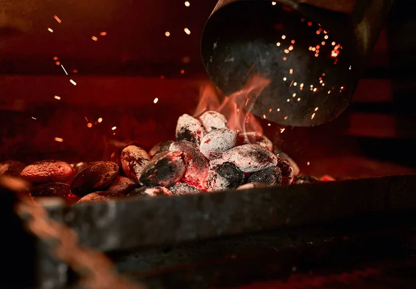 Il n'y a rien de tel que l'odeur d'un barbecue au charbon allumé. Gros plan de charbon de bois brûlant dans une cheminée. — Photo