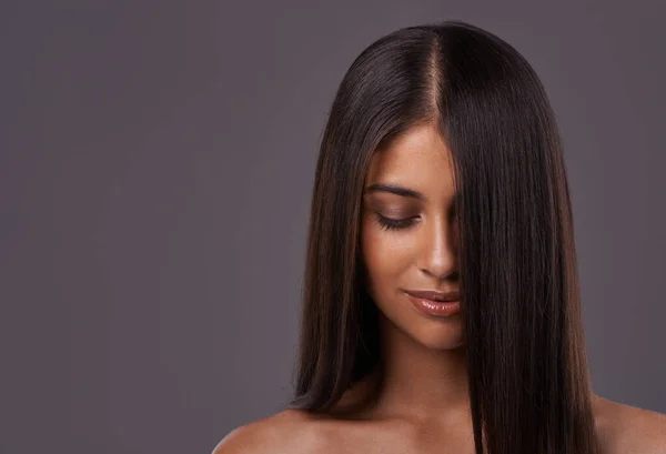 E 'la sua gloria. Una giovane donna con i capelli eleganti in posa in studio. — Foto Stock