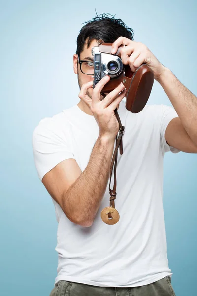Pózolj nekem. Lelőttek egy fiatal férfi fotóst, aki a stúdió hátterével fotózott.. — Stock Fotó