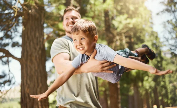 Πετάω με τον μπαμπά. Μια φωτογραφία ενός όμορφου νεαρού να παίζει με τον αξιολάτρευτο γιο του ενώ κατασκηνώνει στο δάσος.. — Φωτογραφία Αρχείου