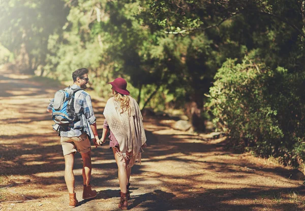 Caminhando pela selva. Foto retrovisada de um jovem casal afetuoso durante uma caminhada. — Fotografia de Stock