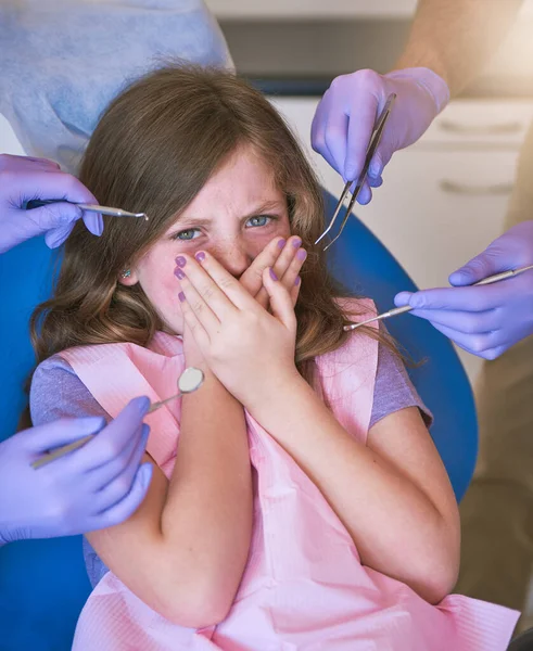 L'ansia dentale infantile è molto comune. Girato di una bambina che sembra terrorizzata mentre i dentisti si preparano ad esaminarla. — Foto Stock