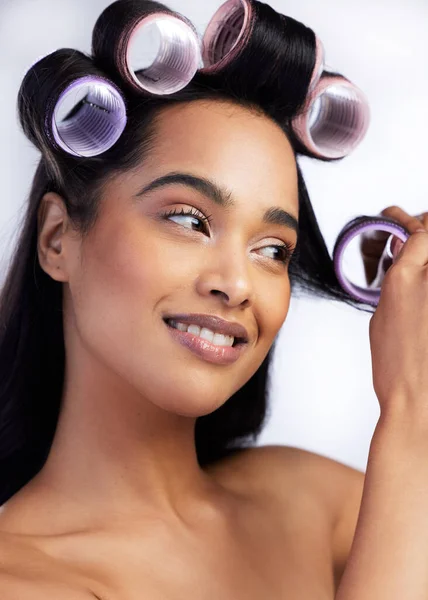 Asegurarse de que su rodó perfectamente. Fotografía de una joven atractiva parada sola en el estudio y usando rodillos en su cabello. —  Fotos de Stock