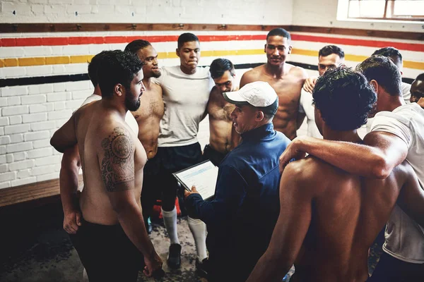 Ive the plan considering our next game. Cropped shot of a rugby coach addressing his team players in a locker room during the day.