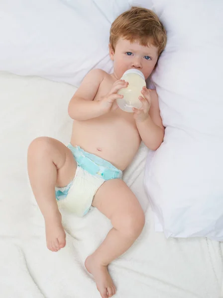 Relaxing with my formula. Full length shot of a sweet little baby lying down drinking a bottle of formula. — Stock Photo, Image