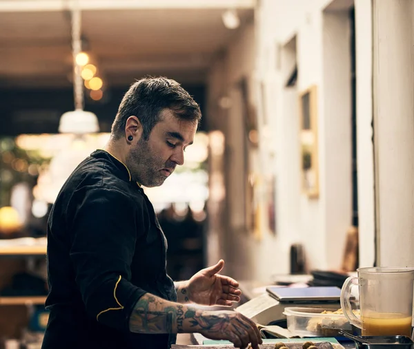 O mestre está a trabalhar. Tiro de um chef focado preparando um prato na cozinha de um restaurante. — Fotografia de Stock