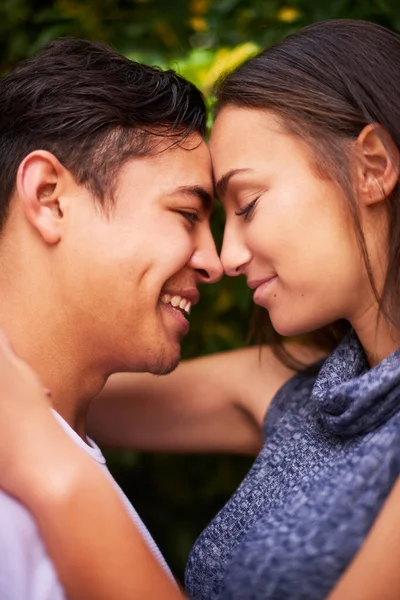 Hanno solo occhi l'uno per l'altra. Primo piano di una giovane coppia sorridente che abbraccia faccia a faccia fuori. — Foto Stock