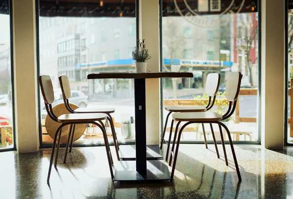 Je kunt overal in het restaurant zitten. Opname van een lege tafel met stoelen in een restaurant overdag. — Stockfoto