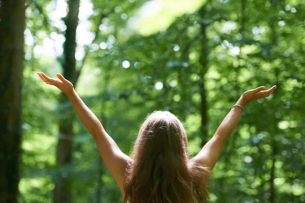 Den Wald genießen. Rückansicht einer schönen jungen Frau mit erhobenen Armen im Wald. — Stockfoto