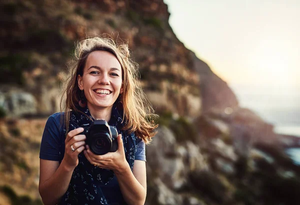 Há tanto para explorar e capturar no mundo. Retrato de uma jovem mulher tirando fotos com sua câmera ao ar livre. — Fotografia de Stock