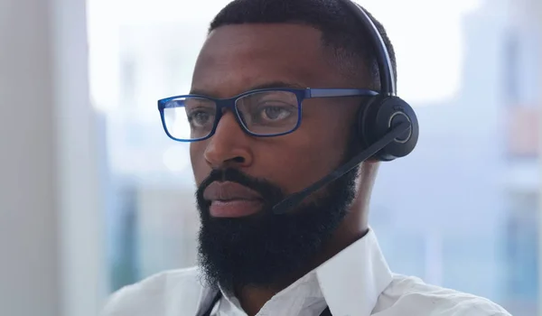 Onderzoek van de beller. Een foto van een jonge zakenman met een headset op zijn werk in een kantoor.. — Stockfoto