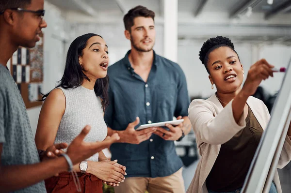 Seeing your plan helps in accomplishing goals. Cropped shot of a diverse group of businesspeople standing together and using a visual aid to brainstorm in the office. — Stock Photo, Image