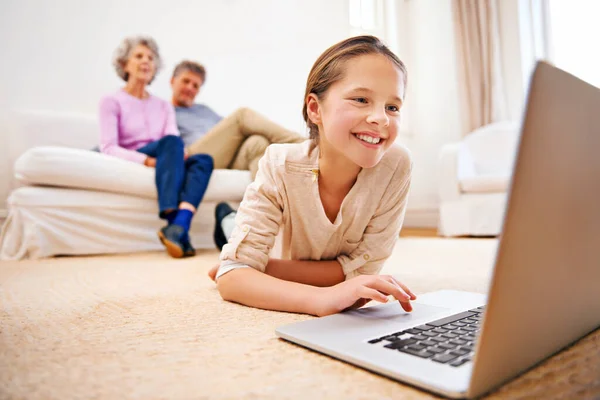 Si intrattiene ovunque. Girato di nonni guardando la loro nipote utilizzando un computer portatile. — Foto Stock