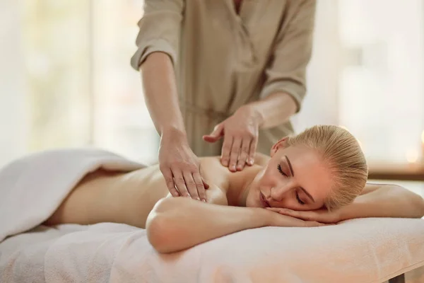 Звільняє напругу від її тіла. Обрізаний знімок молодої жінки, насолоджуючись масажем спини в спа-центрі . — стокове фото