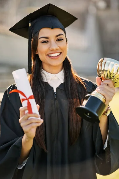 Shes hat sich herausragende Verdienste erworben. Porträt einer Studentin mit Diplom und Trophäe am Abschlusstag. — Stockfoto