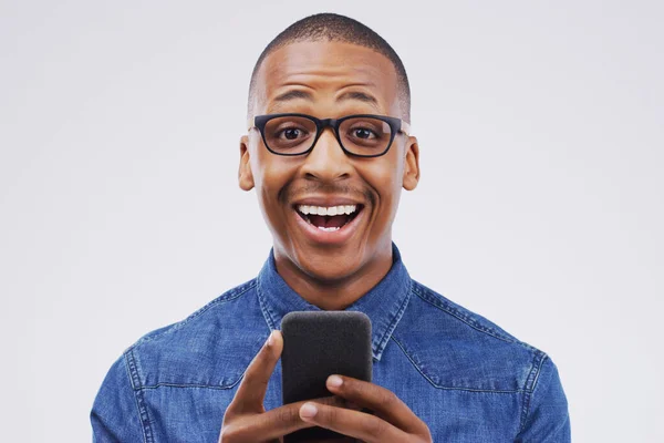 The more airtime I buy, the more they reward me. Studio shot of a handsome young man using his cellphone. — ストック写真