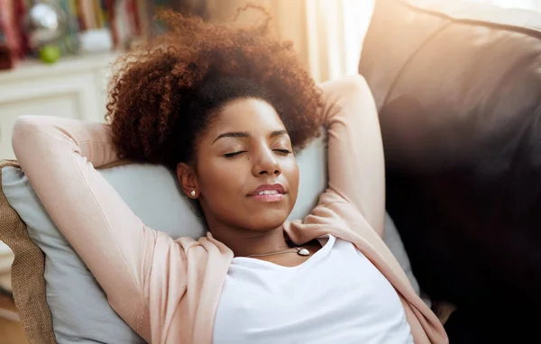 In einem sanften Gemütszustand. Aufnahme einer jungen Frau, die sich zu Hause auf dem Sofa entspannt. — Stockfoto