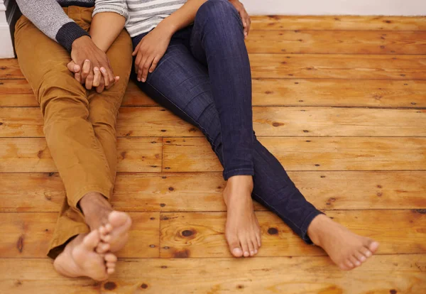 Menemukan cinta di mana saja. Ditembak oleh pasangan yang duduk di lantai dan berpegangan tangan. — Stok Foto