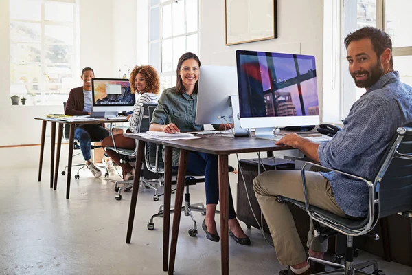 Jejich kancelář je napojená na úspěch. Portrét kolegů pracujících na svých počítačích v otevřené kanceláři. — Stock fotografie