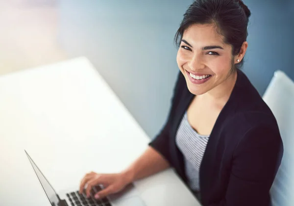 As minhas vistas estão focadas em coisas mais altas. Retrato de alto ângulo de uma jovem empresária atraente trabalhando em um laptop em seu escritório. — Fotografia de Stock
