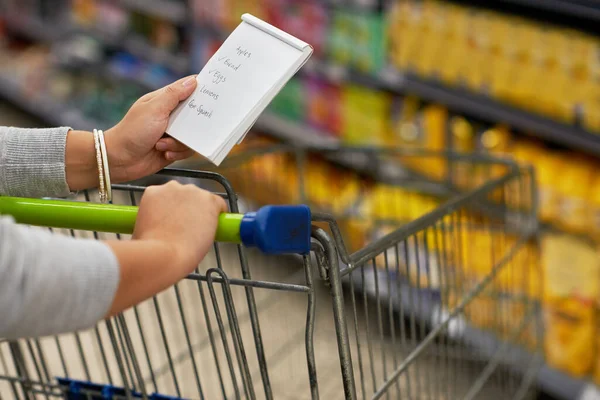 Zakupy z planem. Zbliżenie kobiety sprawdzającej listę zakupów w sklepie spożywczym. — Zdjęcie stockowe