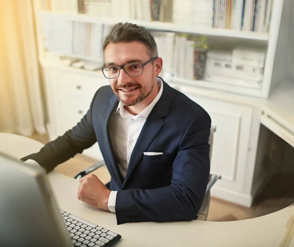 Es el hombre de negocios moderno por excelencia. Retrato de un hombre de negocios que trabaja en su ordenador en una oficina. — Foto de Stock