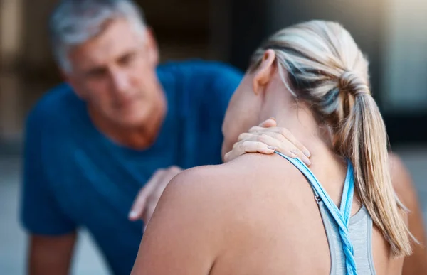 We moeten dat zo snel mogelijk laten nakijken. Schot van een volwassen vrouw houdt haar nek in pijn na een intensieve training sessie met haar man. — Stockfoto