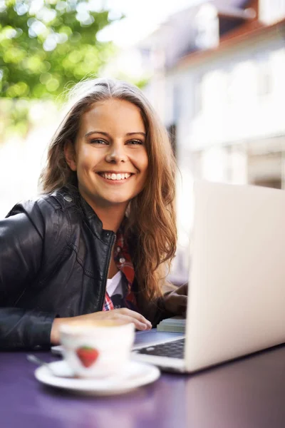 Aproveitando o wi-fi gratuito no bistrô. Retrato de uma bela adolescente trabalhando em seu laptop em um bistrô. — Fotografia de Stock