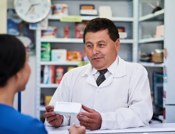 Tome esto 3 veces al día. Inyección de un farmacéutico masculino ayudando a una clienta en una farmacia. — Foto de Stock