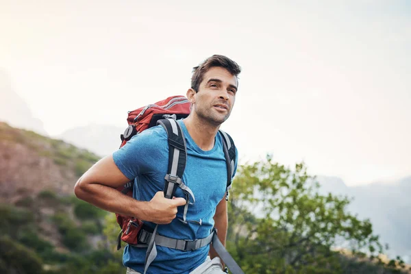 Jag kommer att nå toppen. Beskuren bild av en bekymmerslös ung man tittar i fjärran medan du går för en vandring upp ett berg. — Stockfoto