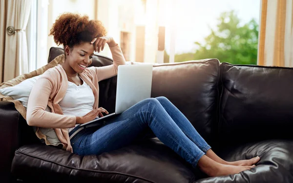 Tener una cita en solitario. Foto de una joven relajada usando un portátil en el sofá en casa. —  Fotos de Stock
