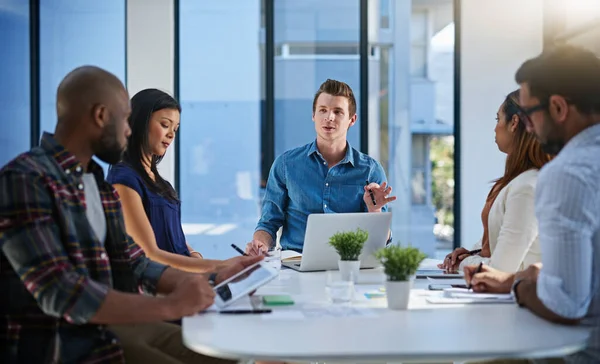 Notiz nehmen und vorausdenken. Aufnahme einer Gruppe junger Geschäftsleute, die bei einem Treffen in einem modernen Büro Ideen miteinander diskutieren. — Stockfoto