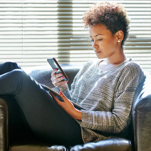 Составляю планы на выходные. Обрезанный снимок молодой женщины с помощью мобильного телефона и цифрового планшета дома. — стоковое фото