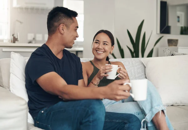 Gespräche beim Kaffee sind ihr Ding. Aufnahme eines jungen Paares, das Kaffee trinkt, während es sich zu Hause entspannt. — Stockfoto
