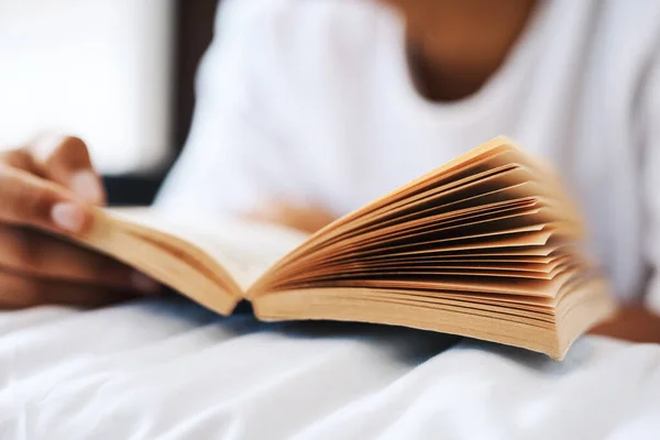 Resta a casa e continua a leggere. Colpo ritagliato di un giovane che legge un libro sdraiato sul letto. — Foto Stock
