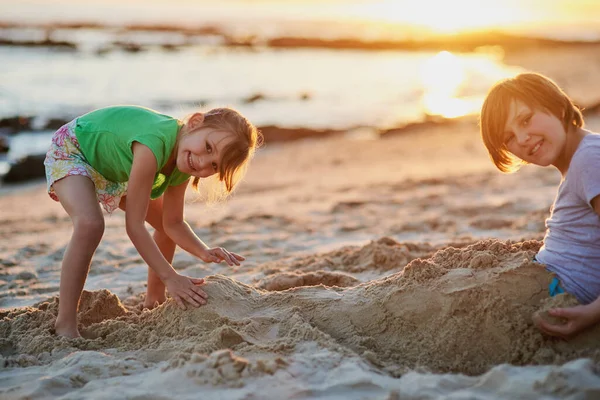 Were going to build the biggest sandcastle ever. Portrait of two young siblings playing together in the sand at the beach. — ストック写真