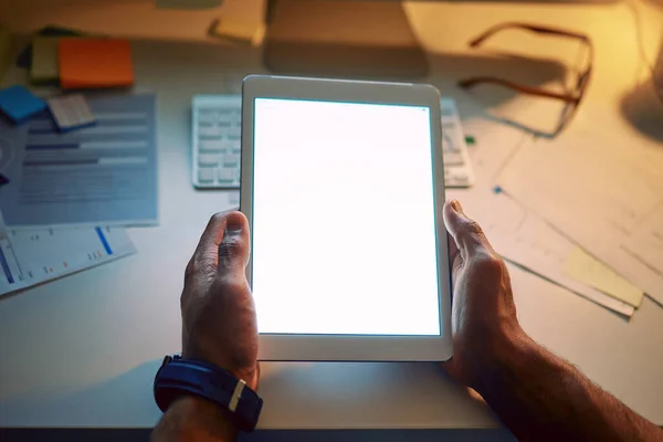 Iluminando los negocios. Recorte de un hombre irreconocible usando una tableta digital durante una noche en el trabajo. — Foto de Stock