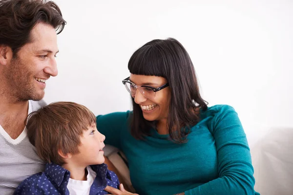 Relajarse en casa con mamá y papá. Un disparo de una joven familia sentada en un sofá. — Foto de Stock