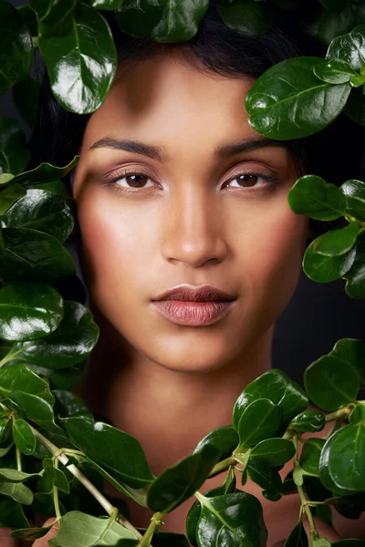 Envuelto en la belleza de la naturaleza. Estudio de una atractiva joven mujer étnica rodeada de hojas. — Foto de Stock