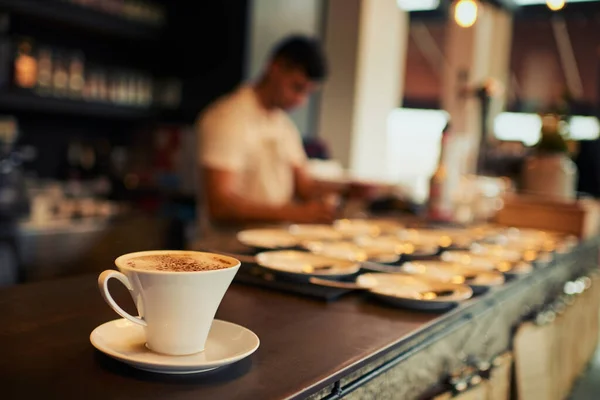 Boldoggá tenni egy ügyfelet. Egy frissen főzött csésze kávé, ami napközben az asztalon áll egy étterem belsejében.. — Stock Fotó