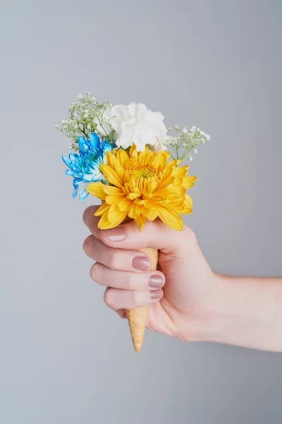 W przeciwieństwie do kwiatów, możesz mieć szyszki o każdej porze roku. Przycięte ujęcie nierozpoznawalnej kobiety trzymającej stożek nadziewany kwiatami. — Zdjęcie stockowe
