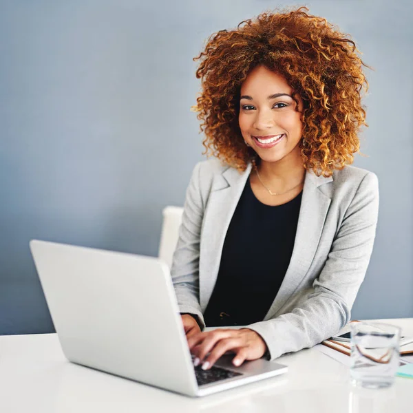 Mijn online bedrijf doet het geweldig. Portret van een jonge zakenvrouw die op een laptop aan haar bureau werkt. — Stockfoto