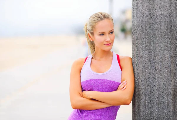 Gericht op fitness. Portret van een jonge vrouw in sportkleding op het strand. — Stockfoto