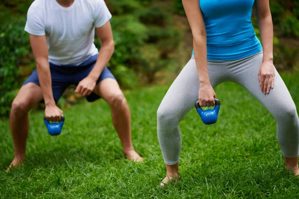 锻炼那些肌肉。在户外运动课上用水壶铃重量拍摄的男女合照. — 图库照片