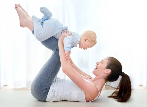 Io e la mamma ci alleniamo. Girato di una giovane donna che si allena mentre trascorre del tempo con il suo bambino. — Foto Stock
