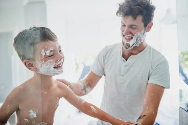 Když se to zkomplikuje, začne to být zábava. Zastřelen, jak otec učí svého malého syna, jak se doma holit v koupelně. — Stock fotografie