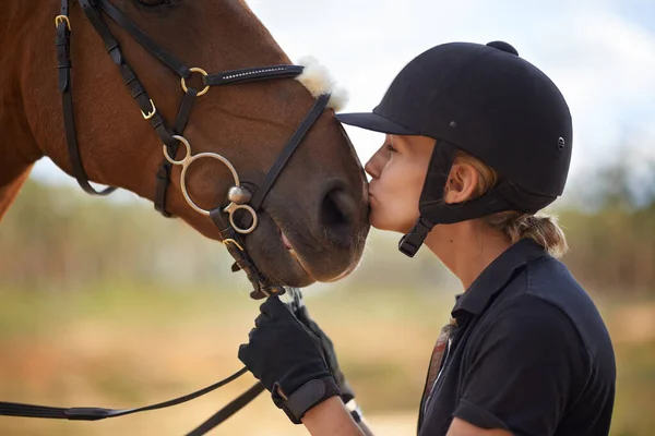 Il y a un lien entre cheval et cavalier. Une jeune cavalière affectueuse avec son cheval marron. — Photo