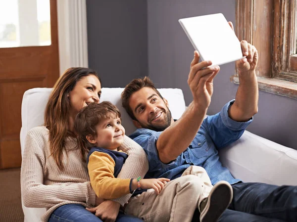 Ώρα για ταινία στη σύγχρονη εποχή. Φωτογραφία μιας ευτυχισμένης οικογένειας με τη χρήση ενός ψηφιακού tablet μαζί. — Φωτογραφία Αρχείου
