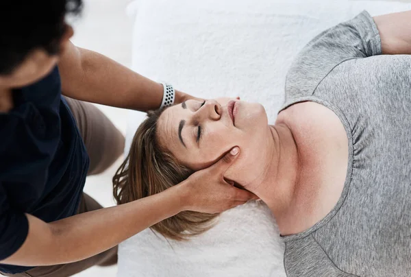 Tu cuello necesita los toques más delicados. Inyección de una mujer madura recibiendo tratamiento de cabeza y cuello por un fisioterapeuta en una clínica. — Foto de Stock